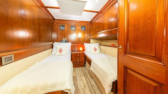 Cosy cabin with two single beds and elegant wood panelling.